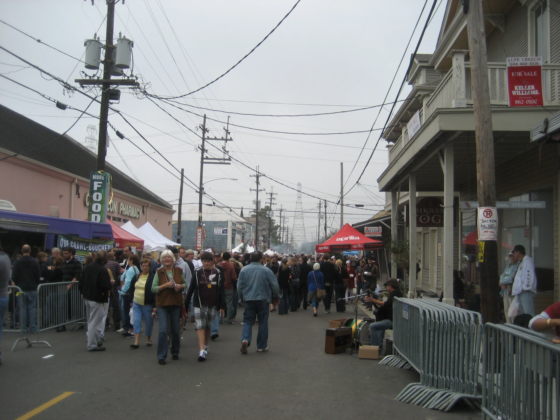 people walking in a city street with people eating food and drinking wine