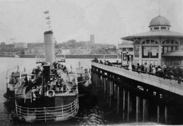 several people are on the dock and near a ship