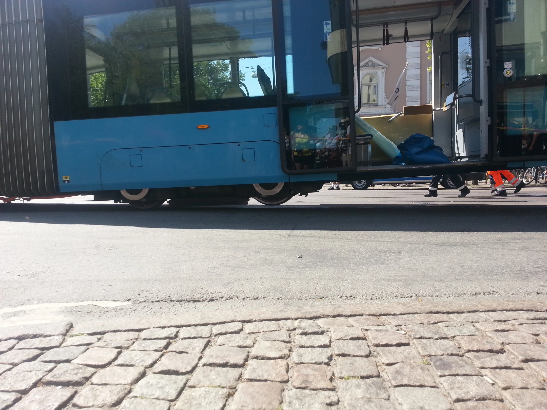 a blue bus parked on the side of a road