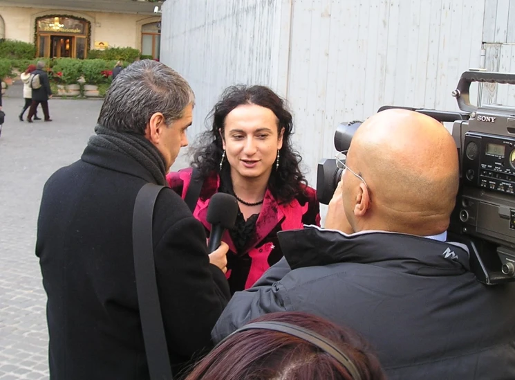 a woman and man speaking to two people in a street