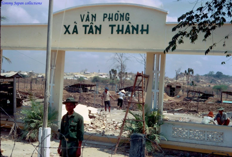the soldier stands under the sign outside in front of the building