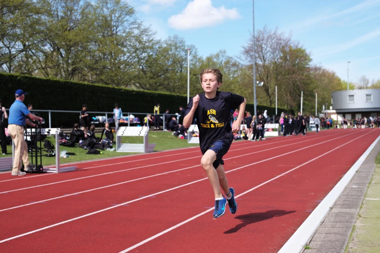 a man racing on a running track during the day