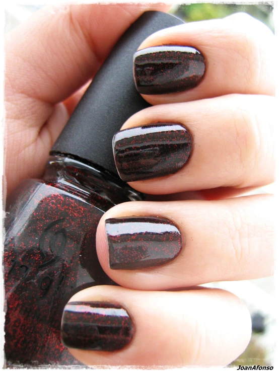 black - and - red manicure is a bold color that stands out against the beige background