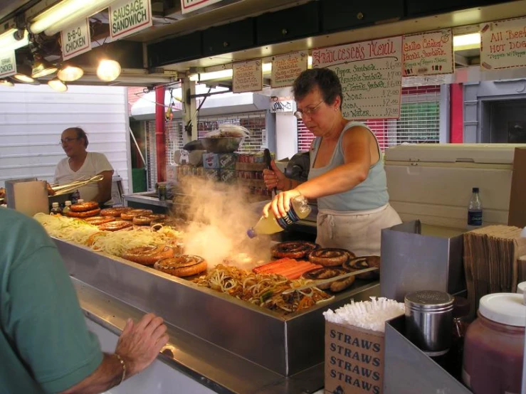 a lady cooking food and a man serving it