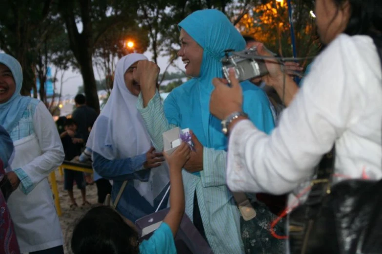 a group of women in hijab smiling at each other