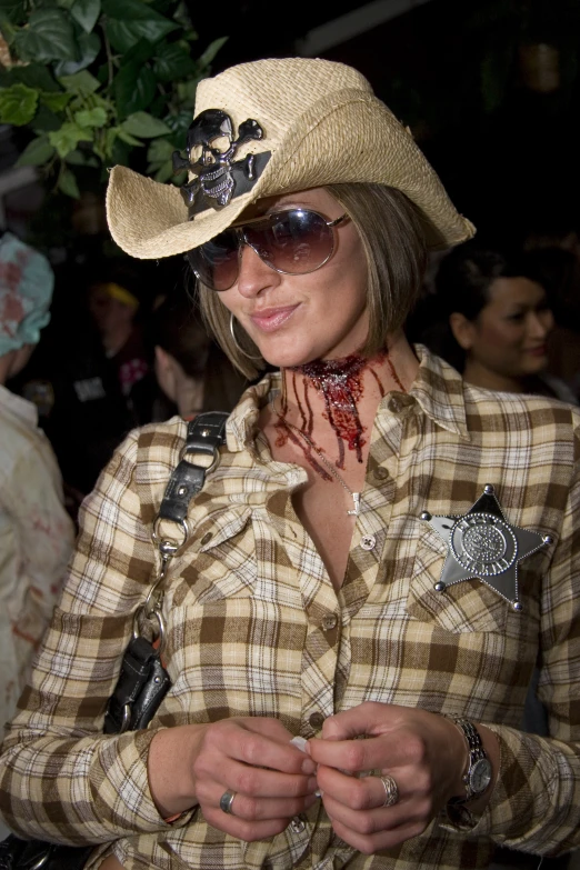 a woman wearing a cowboy hat with a bunch of  on her face