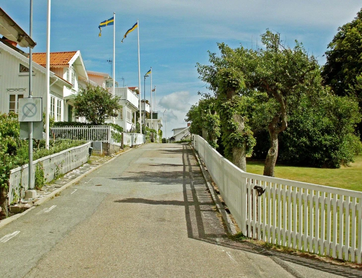 a row of white houses along a wooden gated street