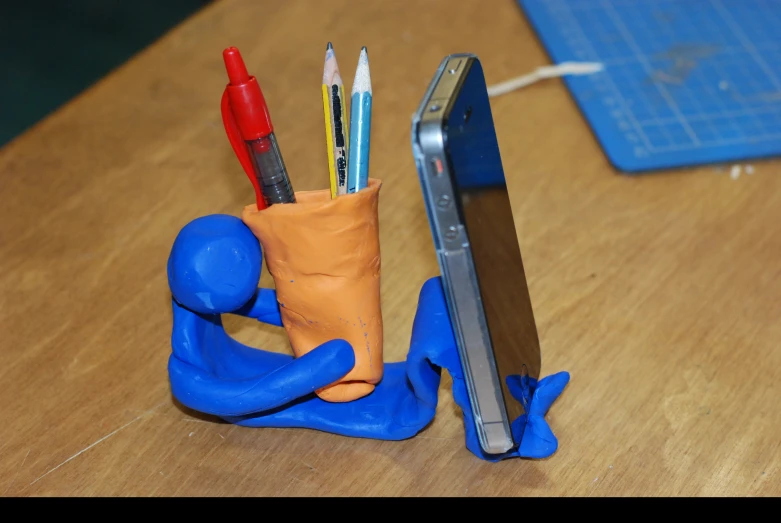 two little markers in a small holder with blue gloves on it