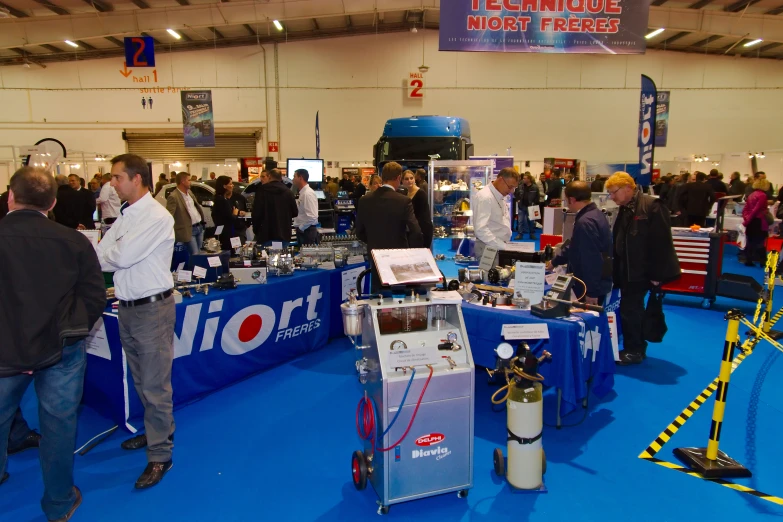 a crowded convention room with people looking at equipment