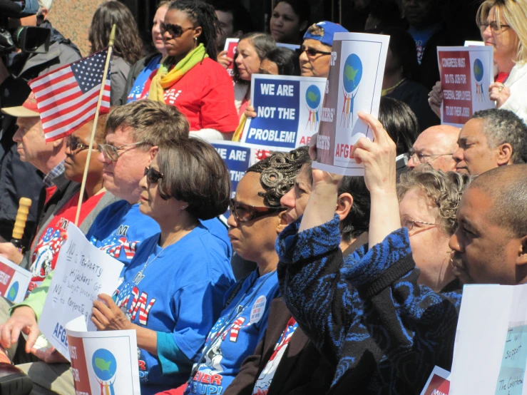 a crowd of people holding signs at a political rally