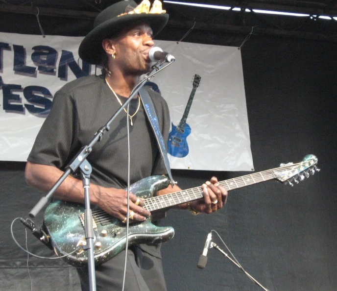 a man that is standing on a stage with a guitar