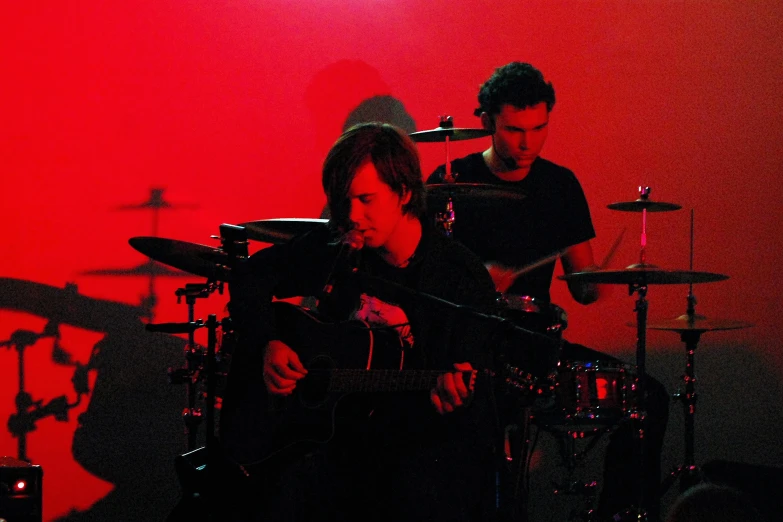 a woman playing the drums while a man plays another drum