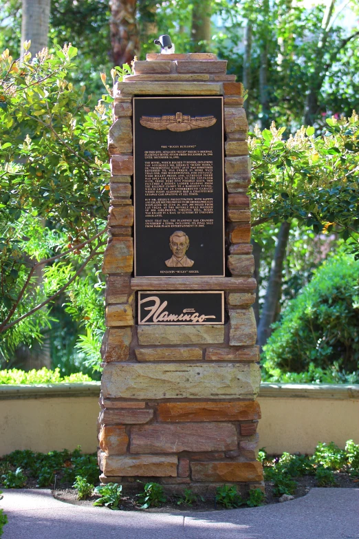 a stone sign sits in front of the park