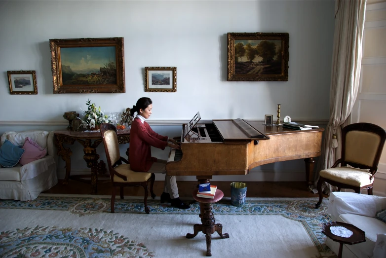 a woman is playing the piano in the room