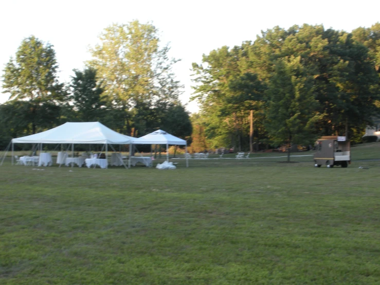 an open field has tables and chairs set up outside