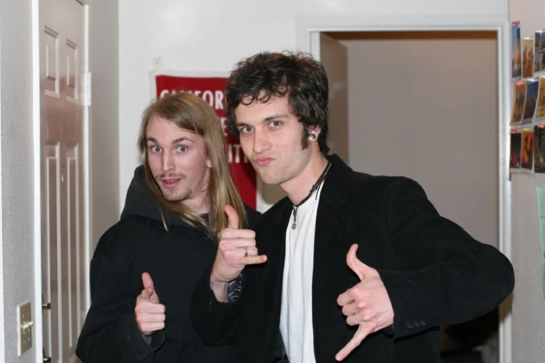 a man with thumbs up standing next to a young woman