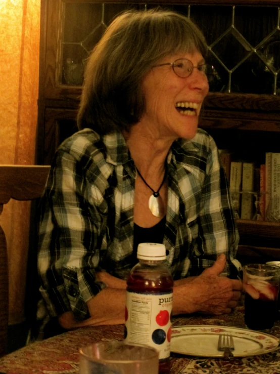 a smiling lady is sitting at a table