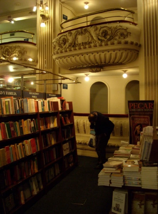 a man in a liry picking up some books