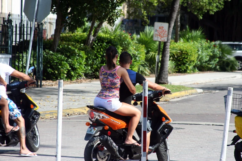 people are riding a scooter in the street