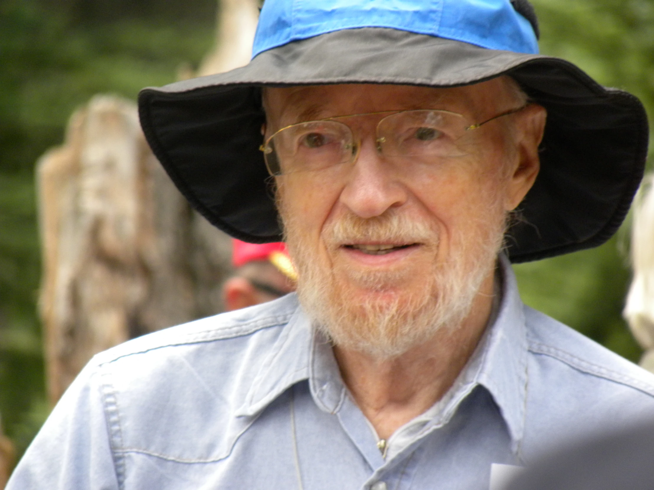 a man in glasses, a hat, and a blue shirt