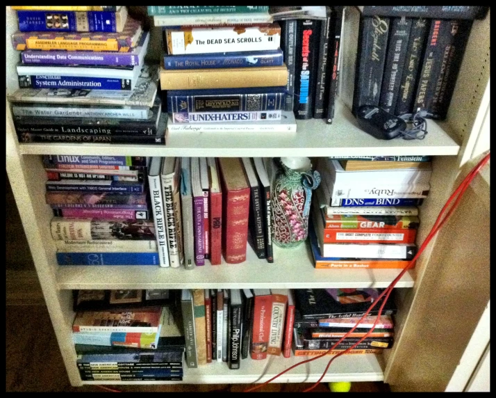 a shelf of books with wires connecting them