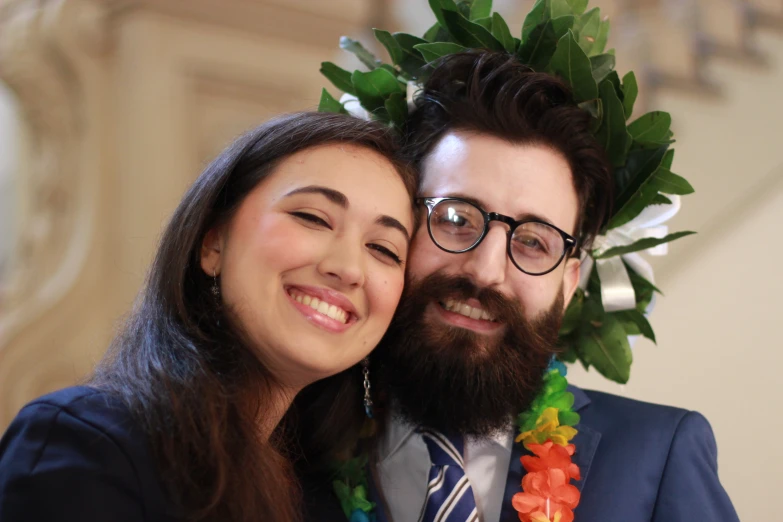 a man with a beard and glasses and woman with flowers in her hair