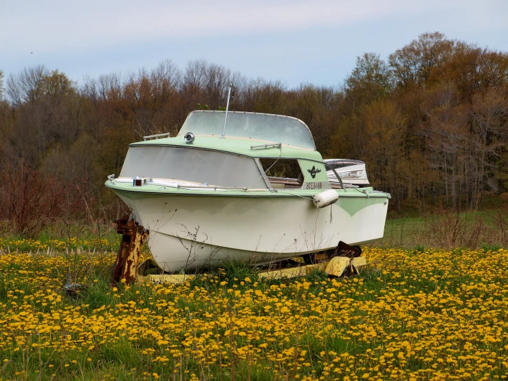 a white boat sitting on top of a grass field