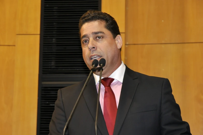 a man in a suit speaking into a microphone