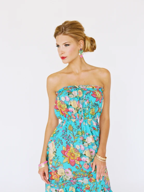 the woman is wearing an aqua dress with flowery designs