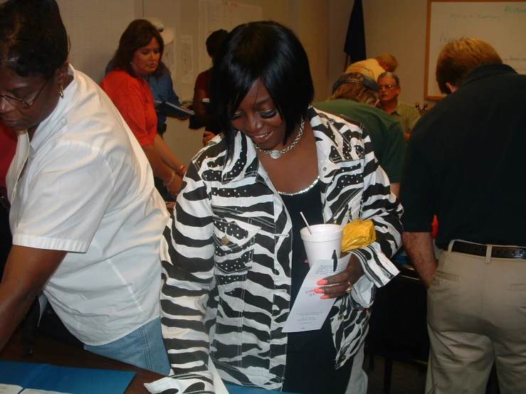 a woman stands with a cup in front of an employee