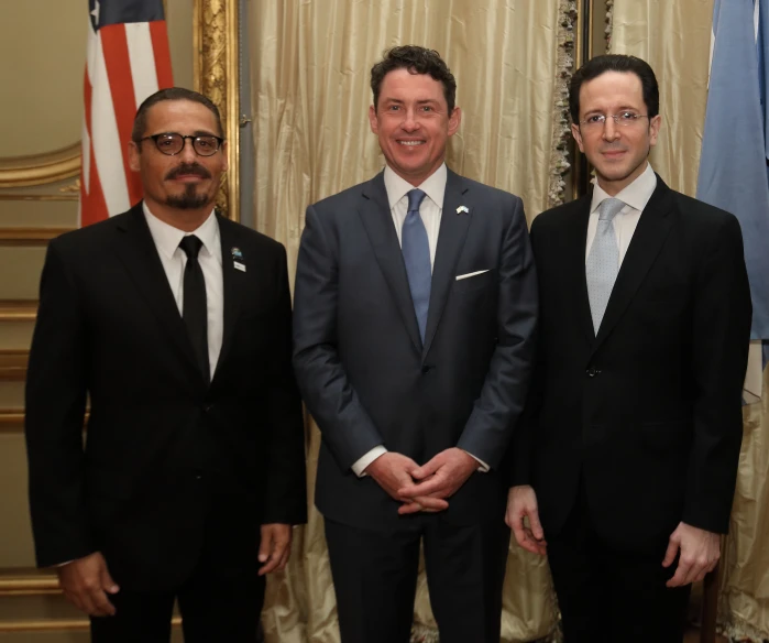 three men in suits are standing next to each other