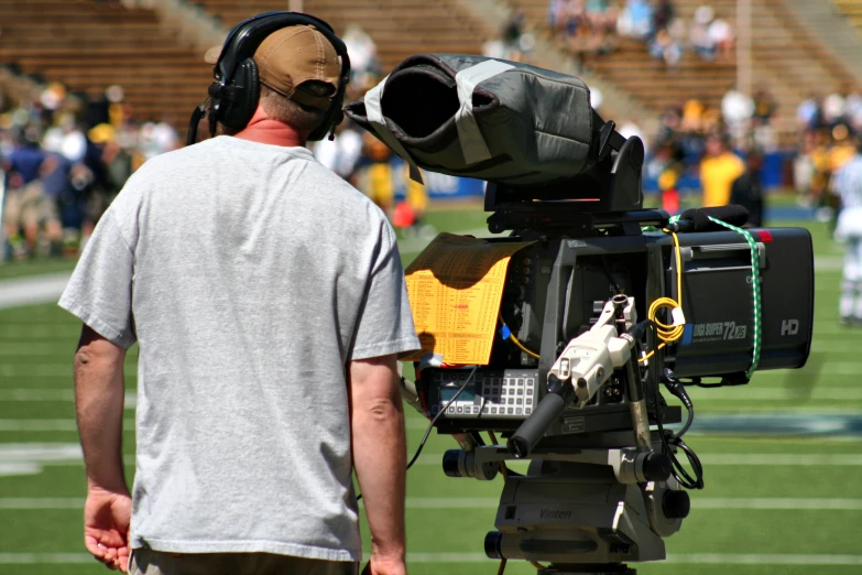 a man standing next to an open camera on top of a field