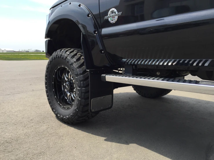 a black pickup truck sitting on top of a street