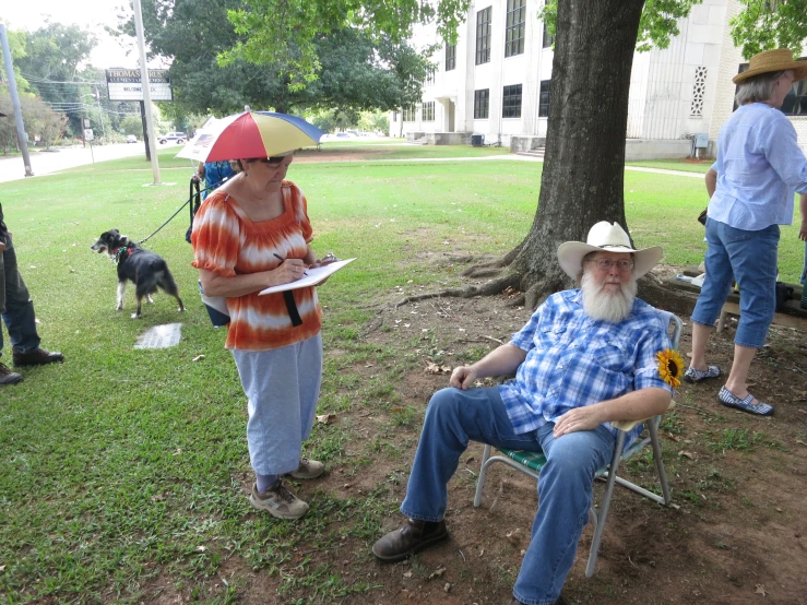 a man sits on a park chair holding a newspaper