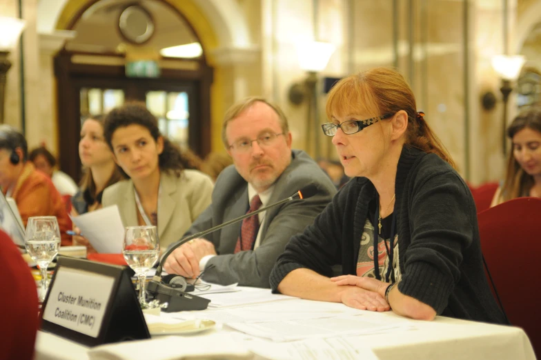 people sitting at a table with some drinks and papers