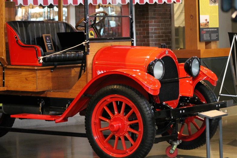an antique car on display with red wheels