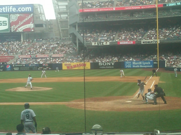 a baseball game in progress as the pitcher throws the ball to home plate