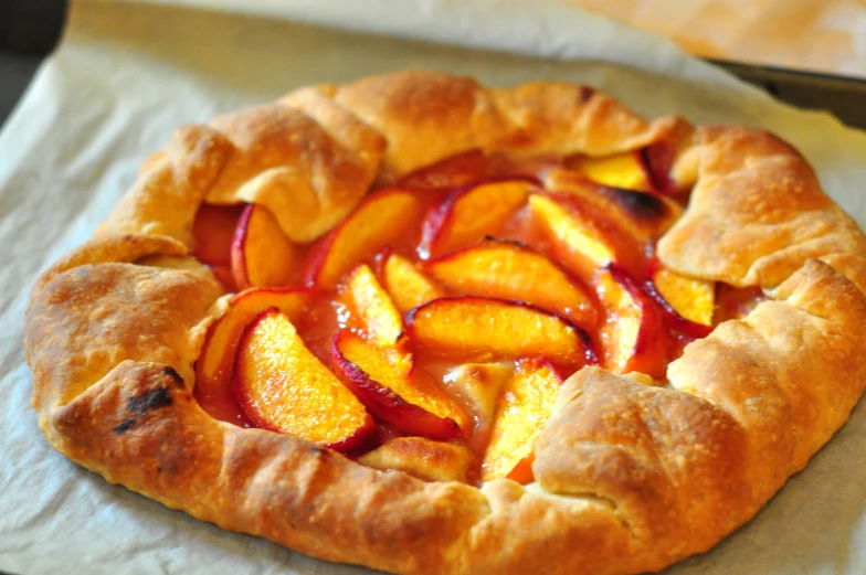 a pizza with a pastry crust topped with nectarines