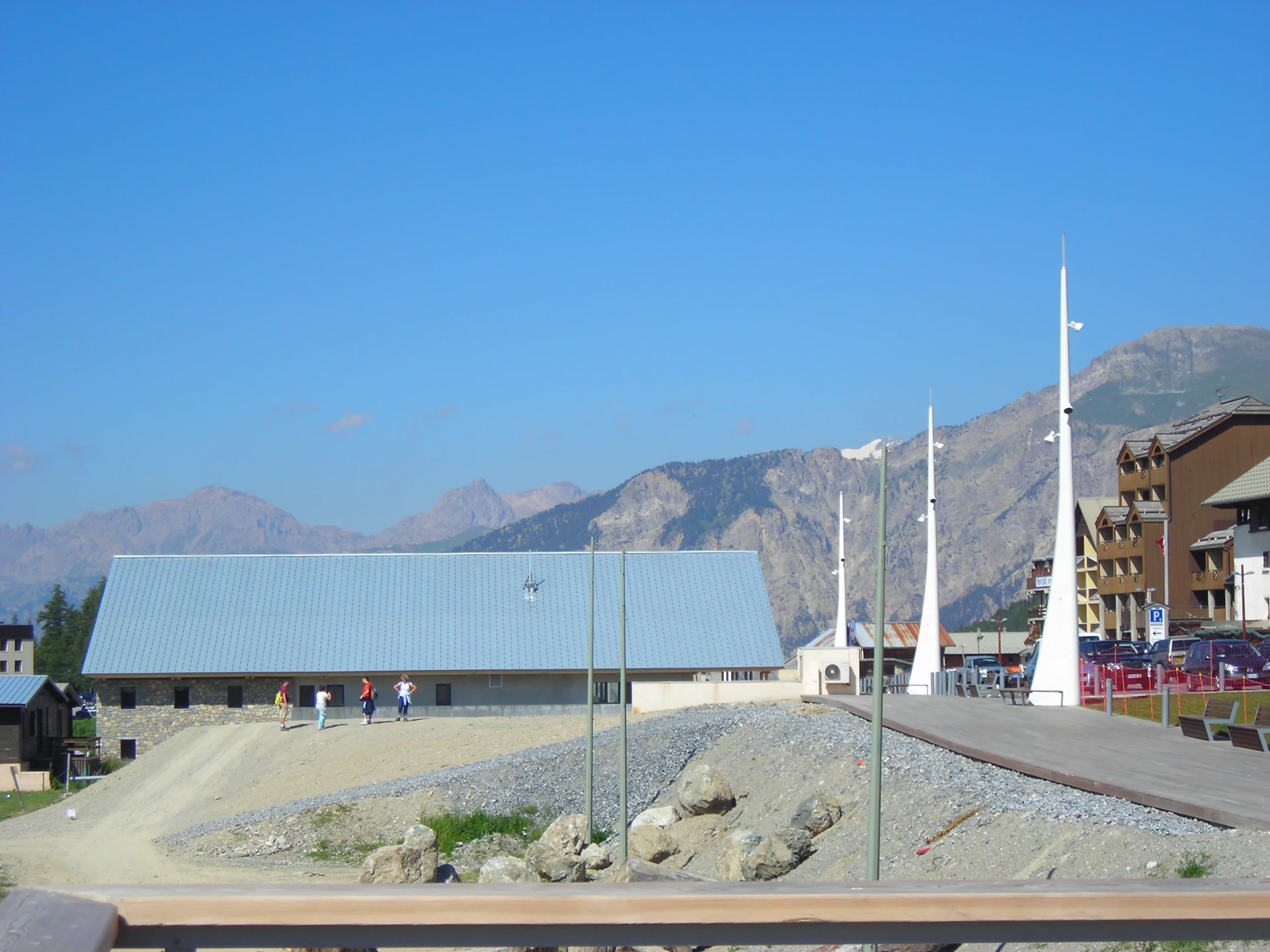 there are flags next to a building in the mountains