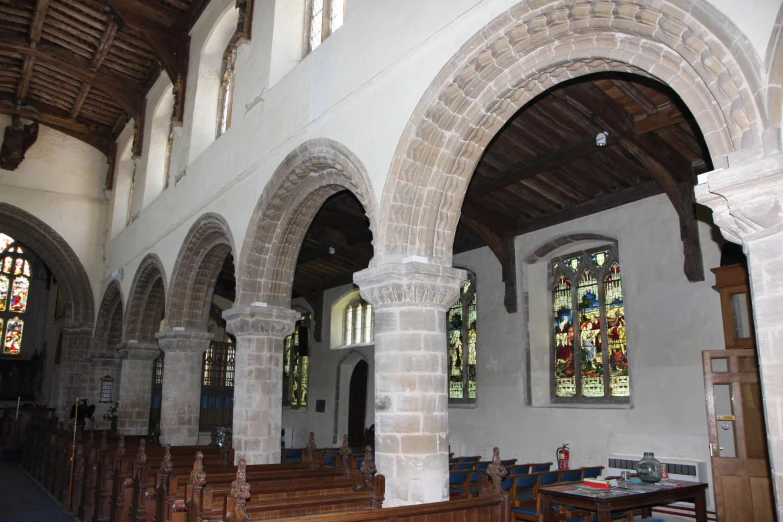 the inside of a church with several wood pews