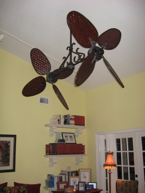 a ceiling fan sitting above a table with lots of books