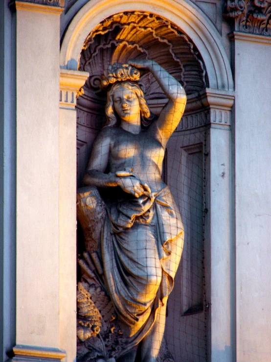 a sculpture of a woman on the corner of a building