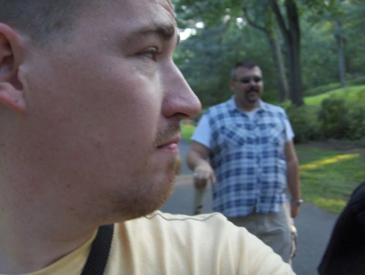 two men stand outside talking to each other