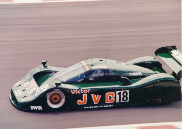 an old racing car driving down a track