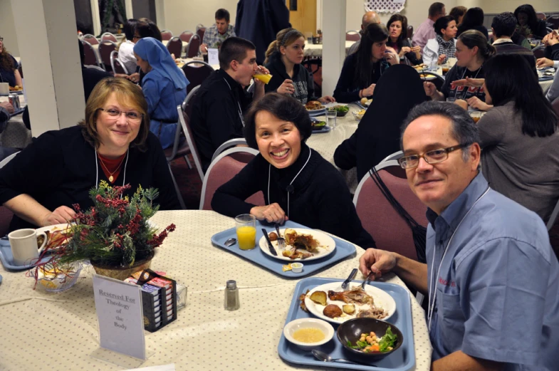 three people sitting at a table eating food