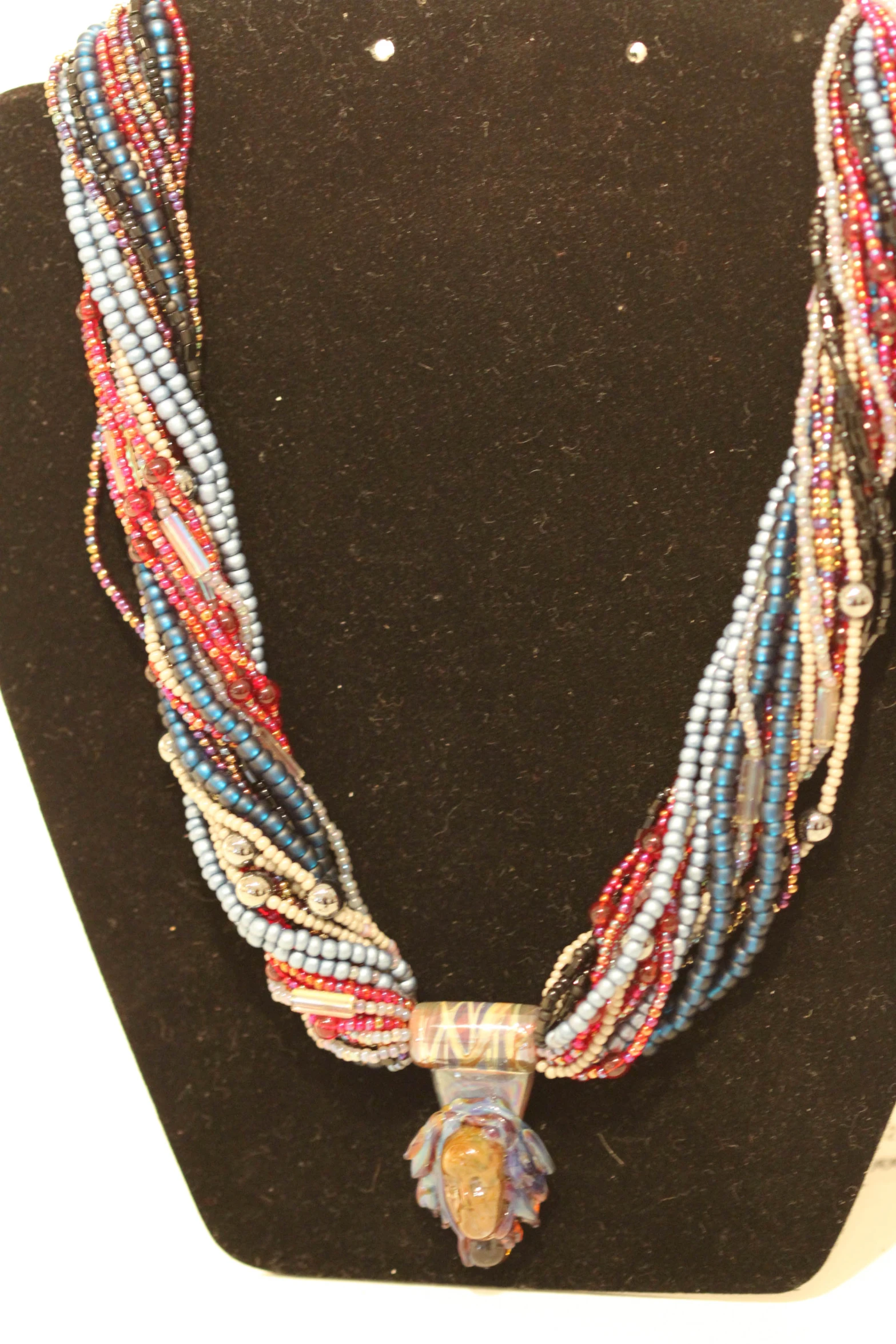 necklace is decorated with beads and an animal head