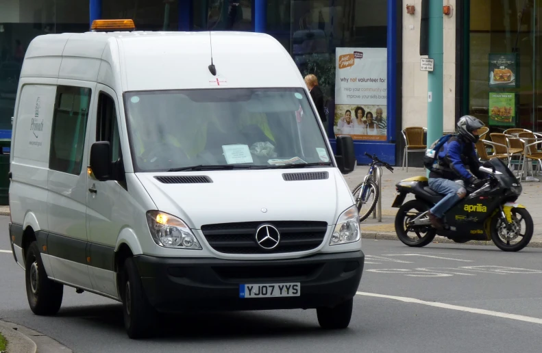 a mercedes benz van driving next to a bike