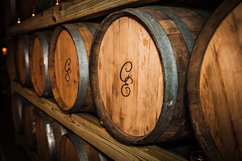 barrels lined up against a wall in a cellar