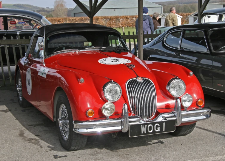 old fashioned car with white decals in front of other cars