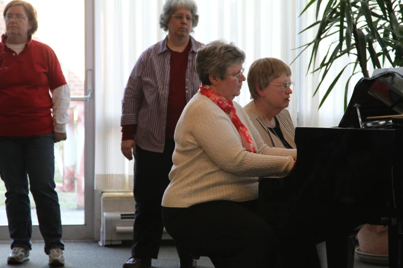 a group of women that are playing piano